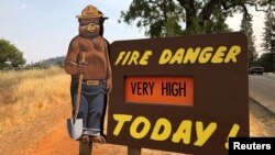 A sign by the side of the road warns of the threat of wildfires, which have been fueled by continued hot weather, outside the town of Colfax, Calif., Aug. 4, 2018.