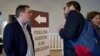 Farmer Jerome Regnault, left, answers questions posed by Germain Milet, right, about his trade. (Lisa Bryant/VOA)