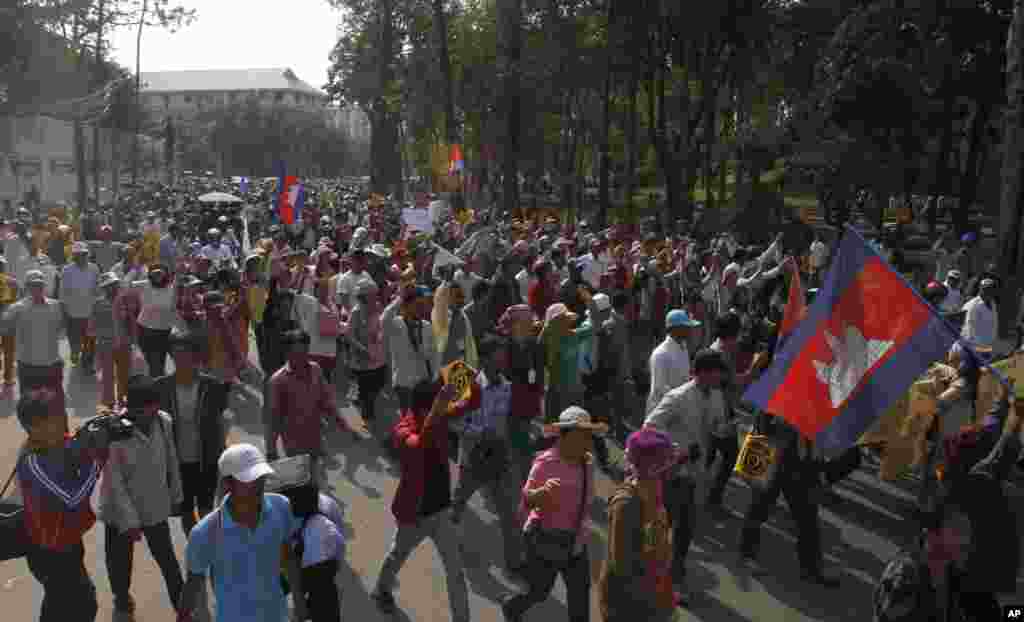 Para demonstran dipimpin oleh aktivis hak asasi manusia Mam Sonando berjalan melewati jalan utama meminta pemerintah mengijinkan pendirian saluran televisi baru di Phnom Penh, 27 Januari 2014.