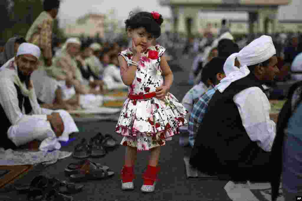 Seorang anak perempuan Yaman berpose ketika menghadiri sholat Idul Fitri bersama ayahnya, di Sanaa, Yaman, 28 Juli 2014.