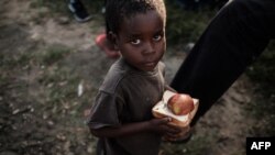 A boy walks after receiving food distribution from a local supermarket at an evacuation center in Dondo, about 35km north from Beira, Mozambique, on March 27, 2019.