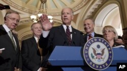 El vicepresidente Joe Biden (centro) junto al líder de la mayoría demócrata, Harry Reid (izq.) tras la votación en el Capitolio.