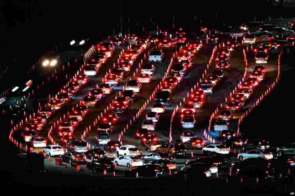 Motorists line up to take a coronavirus test in a parking lot at Dodger Stadium, Jan. 4, 2021, in Los Angeles.