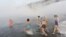 Women follow Mikhail Sashko (L), chairman and one of the founders of the Cryophile winter swimmers club, during a celebration of his 68th birthday in the Yenisei River in the Siberian city of Krasnoyarsk, Russia, Nov. 21, 2015.