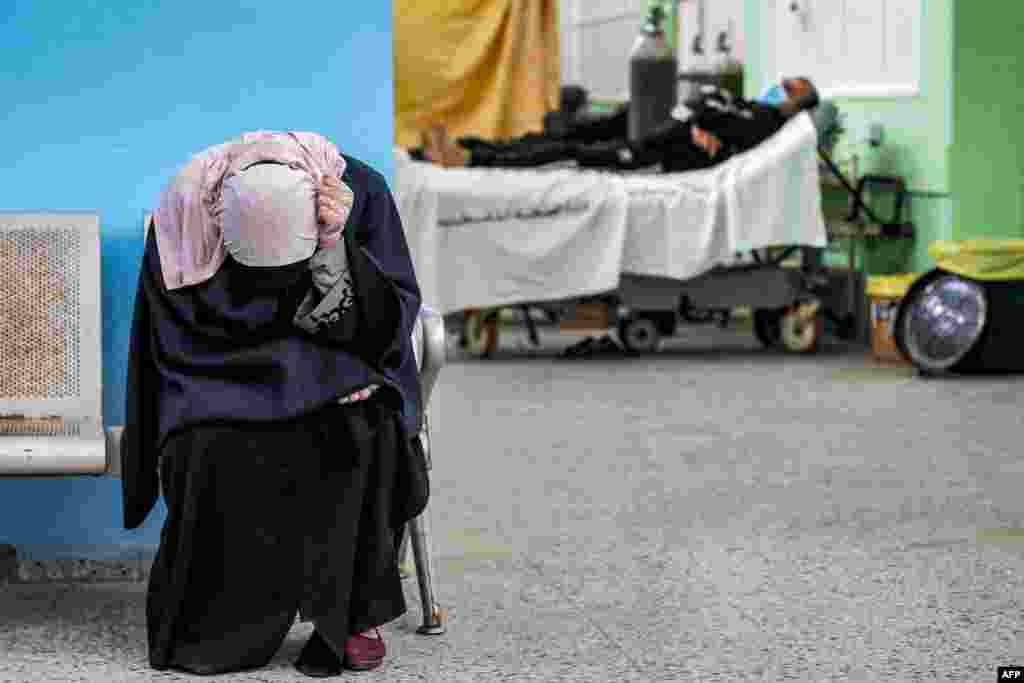 A Palestinian woman reacts while waiting for her husband (background) at the COVID-19 intensive care unit of al-Shifa Hospital in Gaza City.