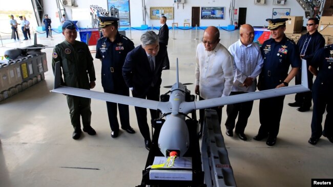 菲律宾国防部长洛伦扎那和美国驻菲律宾大使金成2018年3月13日马尼拉市的一个空军基地视察美国扫描鹰无人机。
