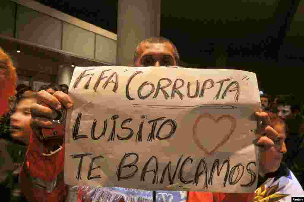 Os fãs do Uruguai exibem um cartaz em solidariedade a Luis Suarez, enquanto esperam por ele à saída do aeroporto internacional Carrasco, em Montevideo, Junho 26, 2014. 