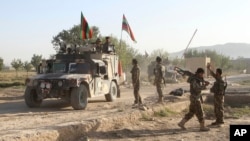 Quân đội Afghanistan đứng gác gần xác chết của một kẻ tấn công Taliban ở phía trước nhà tù chính sau cuộc tấn công ở tỉnh Ghazni, miền đông Afghanistan, ngày 14/9/2015.