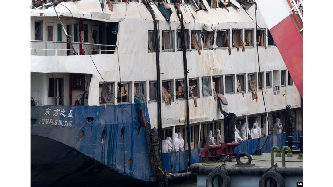 FILE - In this June 7, 2015 photo, rescuers search for passengers' belongings on the raised capsized ship Eastern Star on the Yangtze River in Jianli county of southern China’s Hubei province.