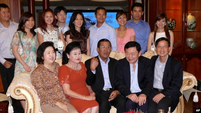 FILE PHOTO - Former Thai Prime Minister Thaksin Shinawatra, second right from the front row, and Cambodian Prime Minister Hun Sen, center, pose for photographs with other members of Hun Sen's family in his residence in Phnom Penh, Cambodia.