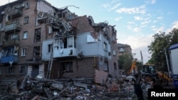 FILE - Rescuers work at the site of a residential building hit by a Russian missile strike, amid Russia's attack on Ukraine, in Kharkiv, May 31, 2024.