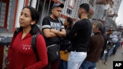 Migrantes venezolanos aguardan frente a la embajada de Venezuela en Lima, Perú, el martes, 4 de septiembre de 2018.