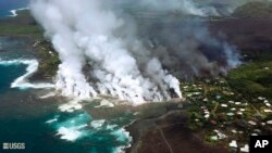 The photo, provided by the U.S. Geological Survey, June 4, 2018, shows lava from a fissure flowing into the ocean at Kapoho Bay at Kapoho on the island of Hawaii. After overrunning the town overnight and destroying hundreds of homes, the lava flowed into the shallow bay and had nearly filled it. 