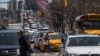 FILE - Pedestrians cross Delancey Street as traffic from Brooklyn enters Manhattan over the Williamsburg Bridge, March 28, 2019, in New York. The Trump administration on Feb. 19, 2025, ordered a halt to a New York City fee system that thins traffic and funds mass transit.