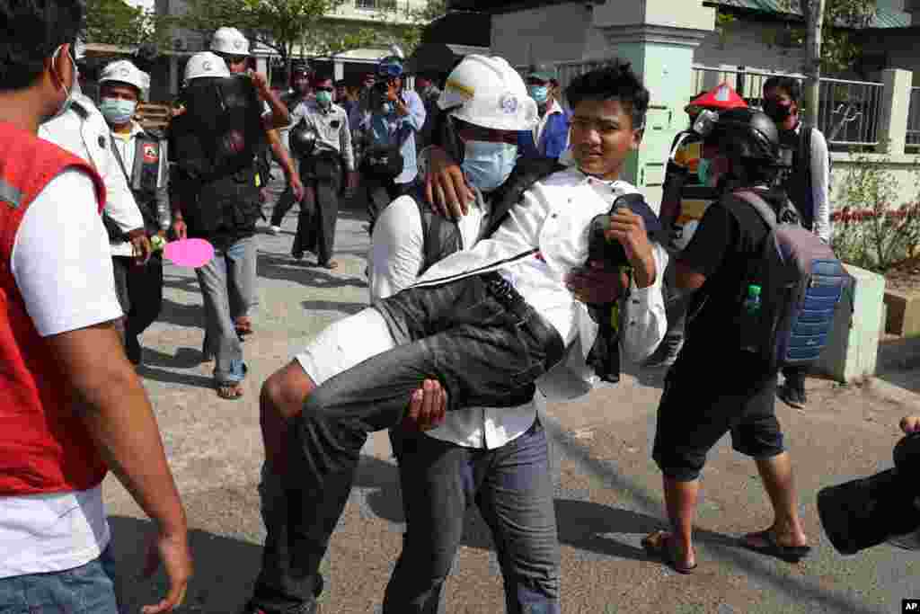 A wounded protester is carried during a protest against the military coup in Mandalay, Myanmar, Feb. 28, 2021.