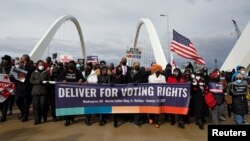 FILE - U.S. civil rights activists hold a Peace Walk on the Frederick Douglass Memorial Bridge to urge Democrats to pass a law protecting voting rights, during Martin Luther King Jr. Day, in Washington, Jan. 17, 2022.
