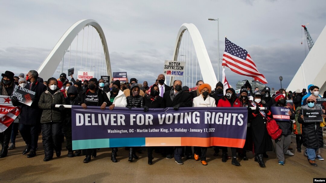 FILE - U.S. civil rights activists hold a Peace Walk on the Frederick Douglass Memorial Bridge to urge Democrats to pass a law protecting voting rights, during Martin Luther King Jr. Day, in Washington, Jan. 17, 2022.