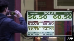 Currency exchange values are displayed on the buy-sell board of a bureau de exchange in Buenos Aires, Aug. 14, 2019.
