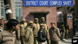 Delhi policemen stand guard near the gate of a district court where the accused in the gang rape and murder of a 23-year-old student are undergoing trial, in New Delhi, India, Jan. 24, 2013. 