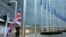 FILE - A member of protocol hoists the British flag outside EU headquarters in Brussels, Belgium, Dec. 4, 2017.