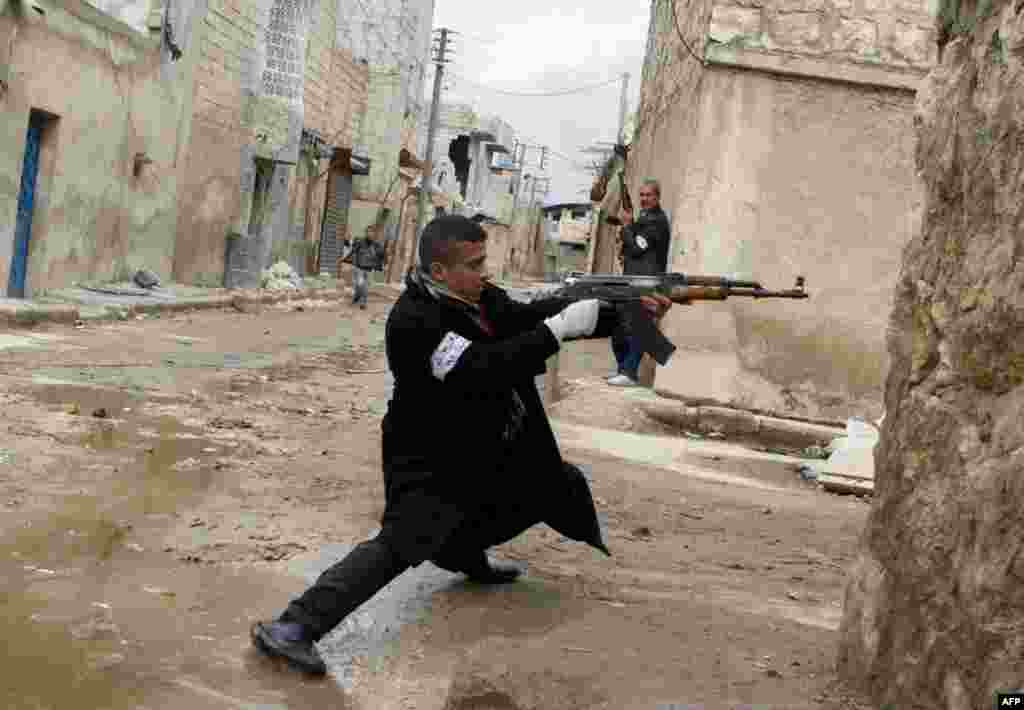 A Syrian rebel aims his weapon during clashes with government forces near Aleppo international airport, March 4, 2013.