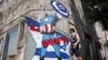 Seorang pria berjalan melewati mural yang menggambarkan Presiden AS Joe Biden berpakaian karakter komik Marvel "Captain America" berdiri di depan bendera Israel dan mengangkat perisai bergambar simbol Bintang Daud, di pinggir jalan kota Tel Aviv. (AFP) 
