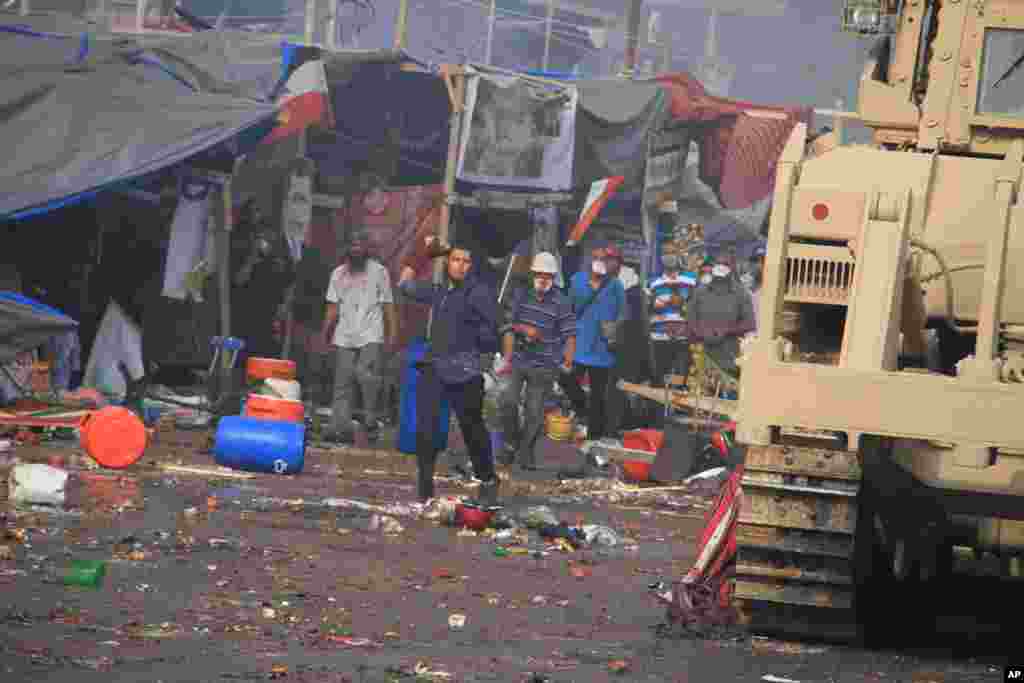 Protesters throw stones at Egyptian security forces trying to clear a sit-in by supporters of ousted Islamist President Mohammed Morsi in the eastern Nasr City district of Cairo, Egypt, Wednesday, Aug. 14, 2013. Egyptian security forces, backed by armored