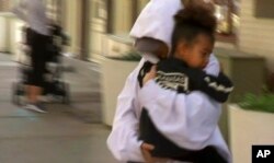 In this image made from video, Kim Kardashian West carries her daughter North West to an awaiting vehicle, Oct. 6, 2016, in New York.