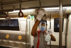 A workers sanitizes a metro coach in New Delhi, India, Sept. 3, 2020.