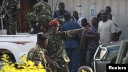 Au centre, l’ancien ministre de la Défense du Burundi, le général Cyrille Ndayirukiye, pointe à une direction lors de la tentative de coup à Bujumbura, Burundi, 13 mai 2015.