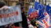 Pro and anti Brexit demonstrators wave their placards and flags outside the Houses of Parliament in London, Dec. 18, 2018.