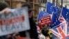 Les manifestants pro et anti-Brexit agitent leurs pancartes et leurs drapeaux devant le Parlement à Londres, le 18 décembre 2018.