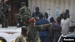 FILE - Burundi's former Defense Minister Cyrille Ndayirukiye, center, points during an attempted coup in the capital Bujumbura, May 13, 2015. 