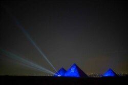 The Great Pyramids of Giza are lit up with a message saying, "Stay Home," April 18, 2020. (Hamada Elrasam/VOA)