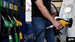 FILE - a man refuels his car at a petrol filling station in Paris, France, on the 32nd day of a strict lockdown aimed at curbing the spread of the COVID-19 pandemic, April 17, 2020.