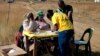 ANC party members check voters before they enter the polling stating in Mount Fletcher, Eastern Cape, South Africa, Wednesday, May 7, 2014. South Africa goes to the polls Wednesday in elections that are likely to see the ruling African National Congress. (AP Photo/Jerome Delay)