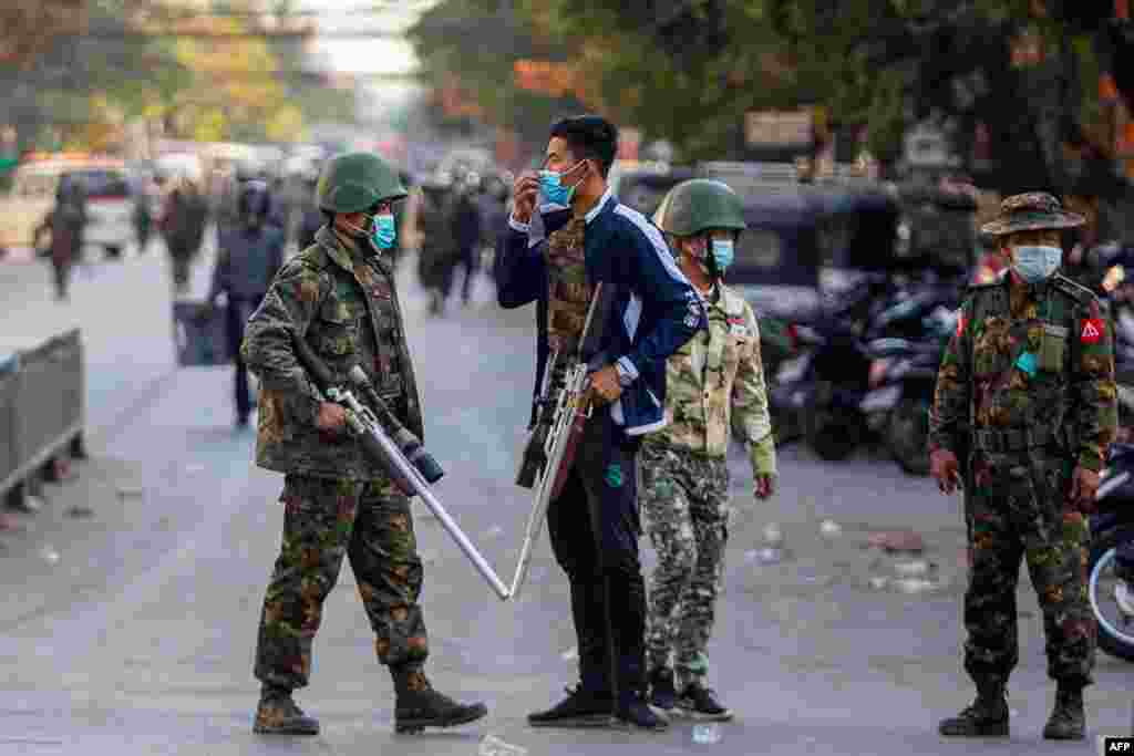 Soldiers carry guns during a clash with protesters demonstrating against the military coup in Mandalay, Myanmar.