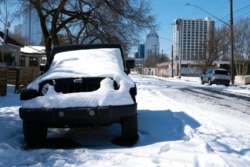 A parked Jeep is covered in snow in Austin, Texas, Feb. 16, 2021.