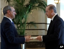 In this Dec. 5, 2016, photo, Turkey's President Recep Tayyip Erdogan, right, and the new Israeli Ambassador Eitan Naeh speak as Naeh presents his letter of credentials, in Ankara, Turkey.
