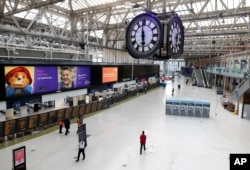 One of London's most famous rendezvous points is nearly empty under the Waterloo train station clock at 1800 in London, April 24, 2020.