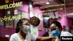Therapists wearing face shields wait for costumers at a traditional Thai massage shop which reopened after the Thai government eased isolation measures to prevent the spread of the coronavirus disease (COVID-19) in Bangkok, Thailand, June 3, 2020. REUTERS