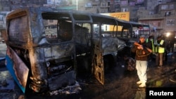 Afghan security forces inspect at the site of a suicide attack on a bus carrying Afghan soldiers, in Kabul, Dec. 13, 2014. 