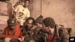 Sub-Saharan migrants sit in a tent they share at Ouled Ziane camp in Casablanca, Morocco, Dec. 6, 2018.