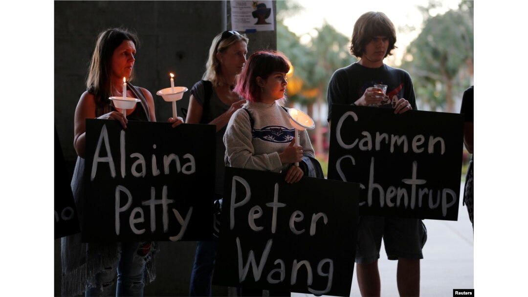 Participants hold placards with the names of victims of the shooting in Parkland, Florida, during a candlelight vigil at Florida Atlantic University in Boca Raton, Florida, Feb. 16, 2018.