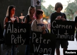 Participants hold placards with the names of victims of the shooting in Parkland, Florida, during a candlelight vigil at Florida Atlantic University in Boca Raton, Florida, Feb. 16, 2018.