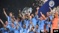 FILES) This picture taken in Istanbul, on June 10, 2023, shows Manchester City's German midfielder #8 Ilkay Gundogan (C) lifts the European Cup trophy as they celebrate on the podium after winning the UEFA Champions League final football match between In