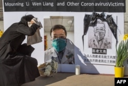 Chinese students hold a memorial for the late Dr. Li Wenliang - who was a whistleblower of COVID-19, that originated in Wuhan, China - outside the UCLA campus in Westwood, Calif. on Feb. 15, 2020.