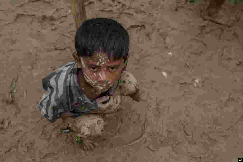 تصویری از پسر بچه مسلمان آواره روهینگیا پس از آنکه با سختی فراوان موفق به عبور از مرز میانمار به بنگلادش شد با بدنی پوشیده از گل در انتظار دست یاری و کمک از سوی امدادرسانان در کمپ پناهندگان بنگلادش نشسته است.