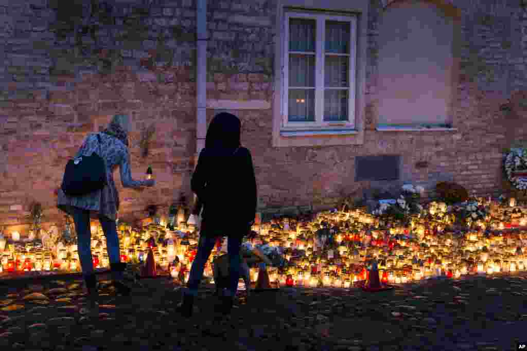 People light candles outside the French Embassy in Vilnius, Lithuania, Nov. 15, 2015, for the victims of Friday's attacks in Paris.
