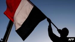 A Yemeni waves a national flag during a rally celebrating the death of Yemeni ex-president Ali Abdullah Saleh a day after he was killed, in the capital Sana'a, Dec. 5, 2017. 